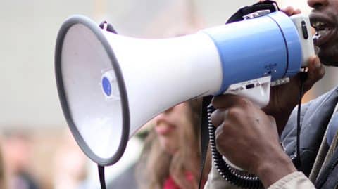 man yelling into megaphone