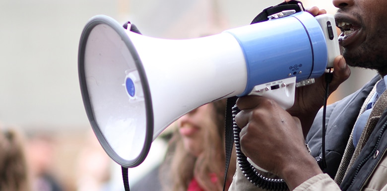 man yelling into megaphone