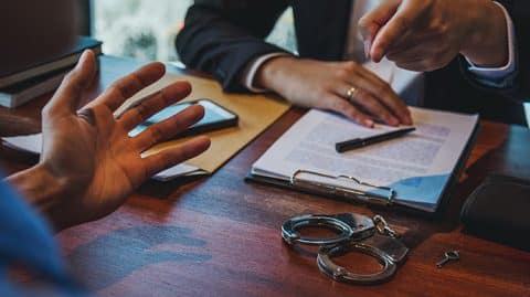 man pointing finger at another over desk