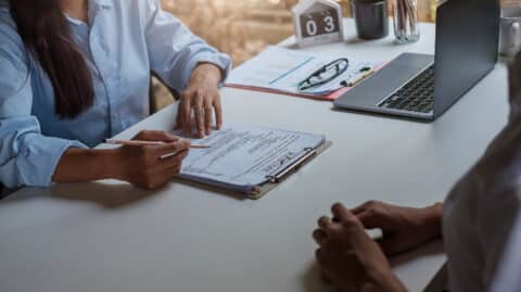 A job interview taking place in an office setting, with a hiring manager reviewing a resume—symbolizing the challenges and possibilities of getting a job in Ohio after a DUI conviction.