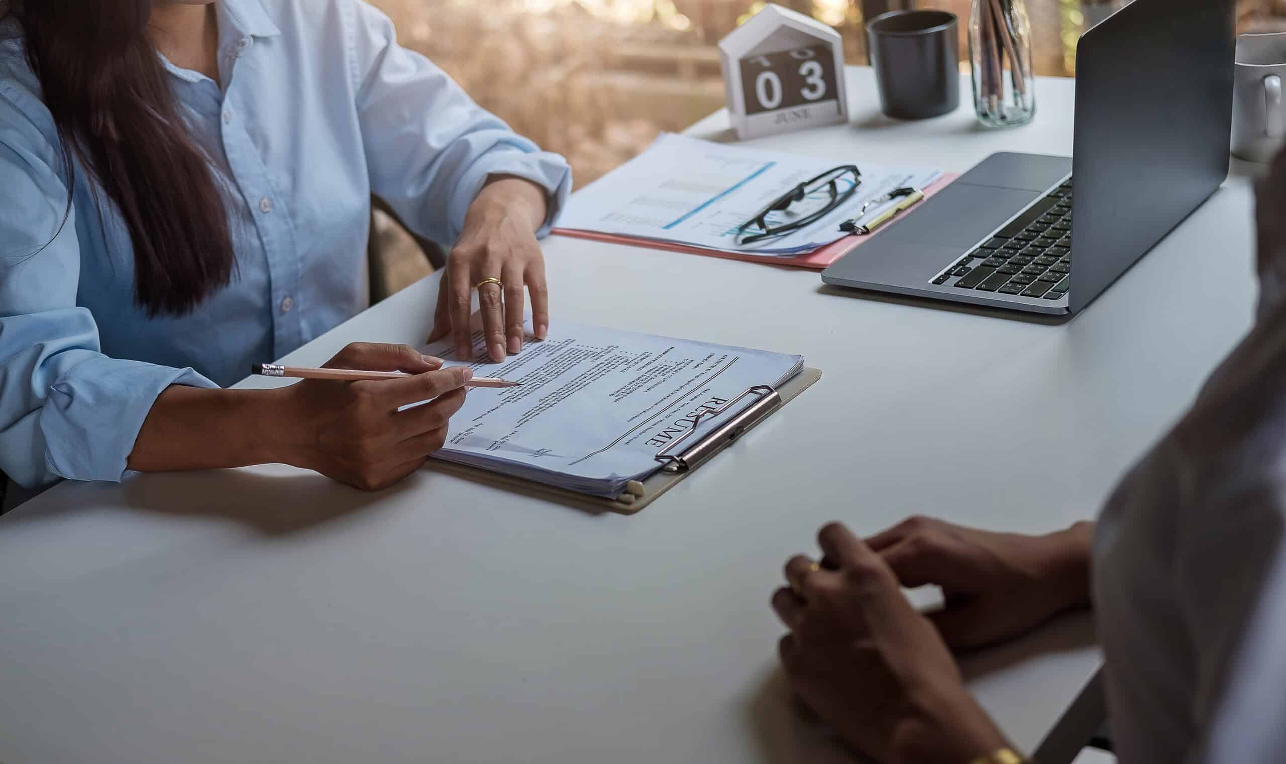 A job interview taking place in an office setting, with a hiring manager reviewing a resume—symbolizing the challenges and possibilities of getting a job in Ohio after a DUI conviction.