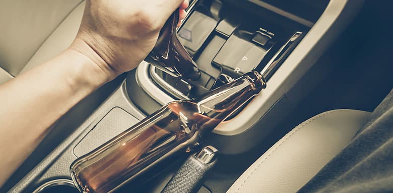 Empty beer bottle on the center console of a car