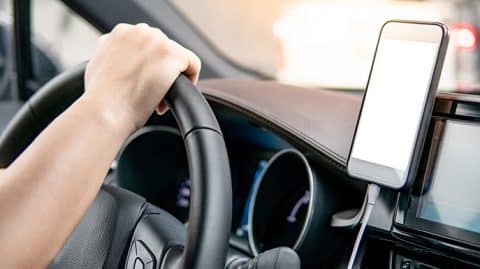 Phone on dash next to driver