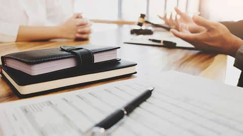 People talking over desk with gavel and documents