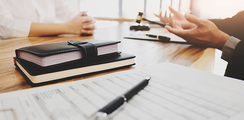 People talking over desk with gavel and documents