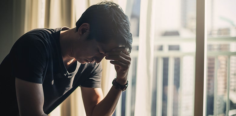 Upset man with head in hands