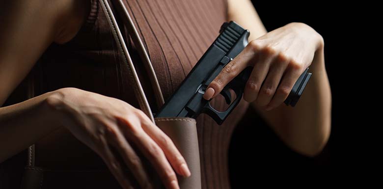 Woman putting handgun in purse