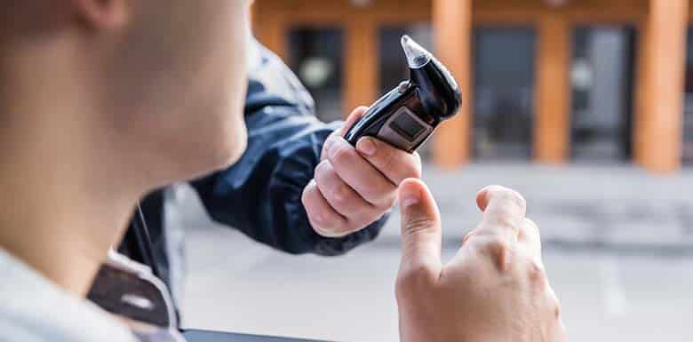 Police handing driver a breathalyzer